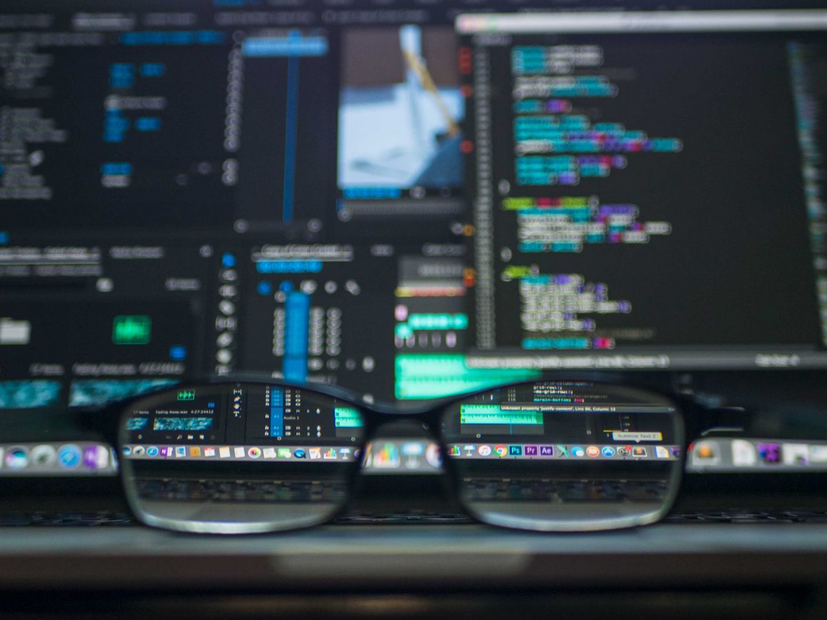 A pair of glassis in front of a computer screen with code